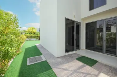 a white house with a yard with green grass at NewArabian Dubai Hills Sidra Villa in Dubai
