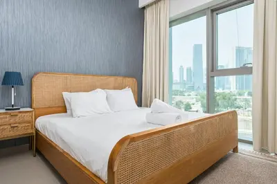 a bedroom with a bed and a large window at BellaVista Downtown Views II Tower 1 Modern 2BR Downtown City View in Dubai