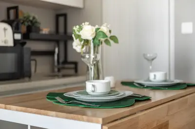 a table with two plates and a vase of flowers at GuestReady - A sophisticated and refined dwelling in Dubai