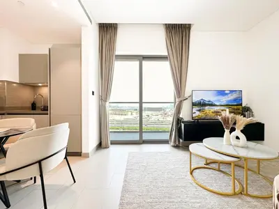a living room with a table and a kitchen at Trophy - Maison de Charme Suite in Dubai