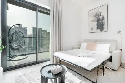 a bedroom with a bed and a large window at Oraya - Studio With Jaw-Dropping Canal and Burj Views - Business bay in Dubai