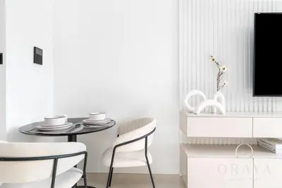 a dining room with a table and a tv at Oraya - Studio With Jaw-Dropping Canal and Burj Views - Business bay in Dubai