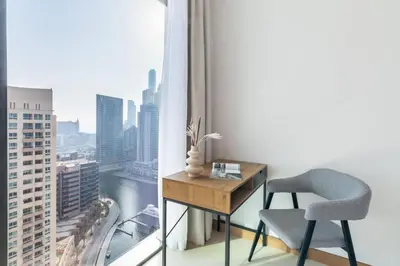 a desk and chair in a room with a window at Welcome Home Apartments - VIDA Marina - Full Marina view - High Floor in Dubai