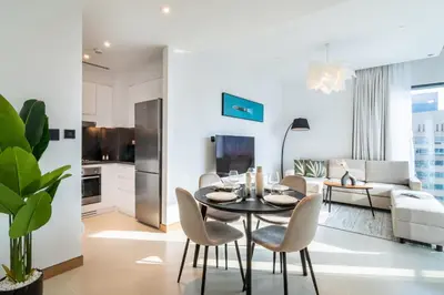 a dining room and living room with a table and chairs at Welcome Home Apartments - VIDA Marina - Full Marina view - High Floor in Dubai