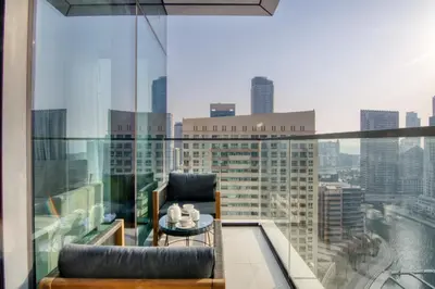 a balcony with a table and a chair on a building at Welcome Home Apartments - VIDA Marina - Full Marina view - High Floor in Dubai