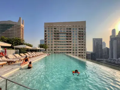 a pool on top of a building with people in the water at Welcome Home Apartments - VIDA Marina - Full Marina view - High Floor in Dubai