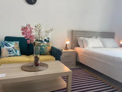 a room with a bed and a table with a vase of flowers at Studio in Silicon Oasis in Dubai