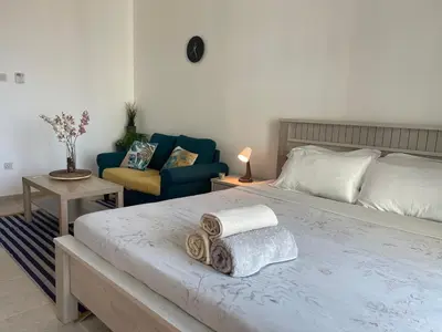 a bedroom with a bed and a couch and a chair at Studio in Silicon Oasis in Dubai