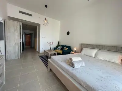 a bedroom with a large bed and a living room at Studio in Silicon Oasis in Dubai