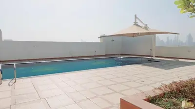 a swimming pool on top of a building with an umbrella at Havana Holiday Homes Oud Metha in Dubai