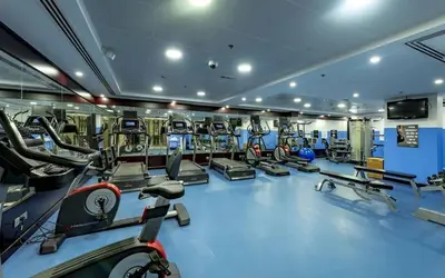 a gym with several treadmills and cardio machines at Havana Holiday Homes Oud Metha in Dubai