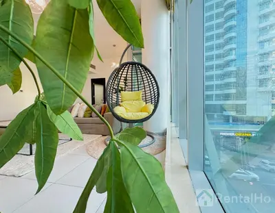 a room with a chair and a plant at Lxry Full Marina View & RoofTop Pool 40% OFF in Dubai