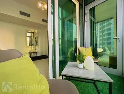 a room with a bed and a table and a balcony at Lxry Full Marina View & RoofTop Pool 40% OFF in Dubai