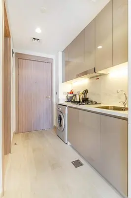 a kitchen with a washer and dryer next to a door at Modern Stu Near Downtown Dubai Pool Gym WiFi in Dubai