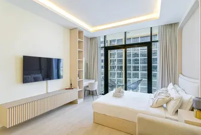 a hotel room with a bed and a tv at Modern Stu Near Downtown Dubai Pool Gym WiFi in Dubai