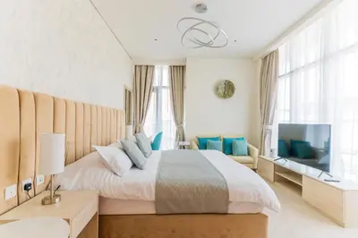 a bedroom with a large bed and a flat screen tv at Studio with private beach access at Palm Jumeirah in Dubai