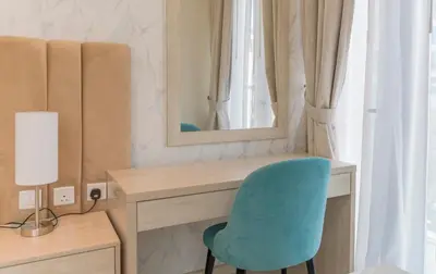 a desk with a blue chair and a mirror at Studio with private beach access at Palm Jumeirah in Dubai