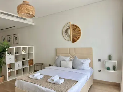 a bedroom with a bed with two towels on it at Spacious Minimalistic Studio in Dubai