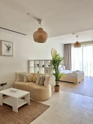 a living room with a couch and a bed at Spacious Minimalistic Studio in Dubai