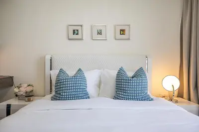 a bedroom with a white bed with blue pillows at Exclusive Spacious Villa I Garden I Maid Room in Dubai