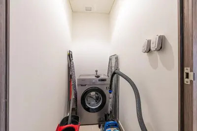 a washing machine in a corner of a room at Exclusive Spacious Villa I Garden I Maid Room in Dubai