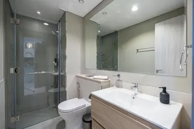 a bathroom with a toilet and a sink and a shower at Keyrock Living - Lakeview Escape in Business Bay in Dubai