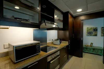 a kitchen with wooden cabinets and a microwave at Elegant Apartment Overlooking Dubai Mall Fountain. in Dubai