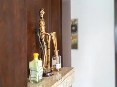 a shelf with a statue of a man and bottles on it at Elegant Apartment Overlooking Dubai Mall Fountain. in Dubai