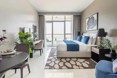 a hotel room with a bed and a dining room at Frank Porter - DAMAC Artesia in Dubai
