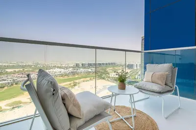 a room with two chairs and a table on a balcony at Frank Porter - DAMAC Artesia in Dubai