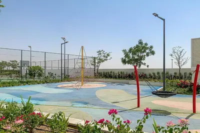 a park with a playground with swings and flowers at Frank Porter - DAMAC Artesia in Dubai