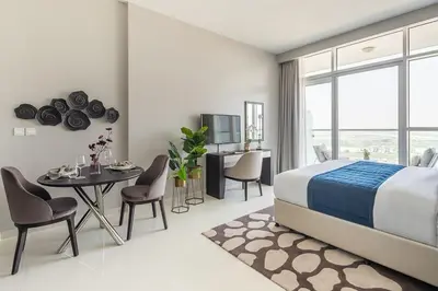 a bedroom with a bed and a table and chairs at Frank Porter - DAMAC Artesia in Dubai
