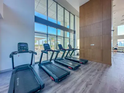 a row of treadmills in a gym with a building at Modern 1BR at Farhad Azizi Al Jaddaf - Sleeps 4 in Dubai