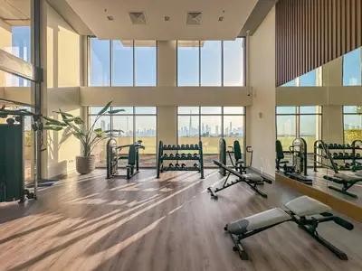 a gym with cardio equipment in a building with windows at Modern 1BR at Farhad Azizi Al Jaddaf - Sleeps 4 in Dubai