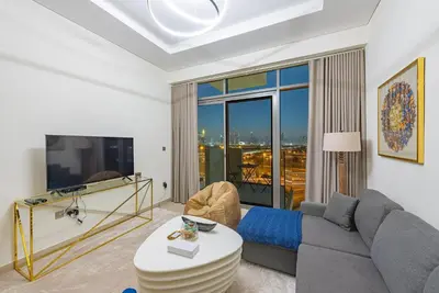a living room with a couch and a tv at Modern 1BR at Farhad Azizi Al Jaddaf - Sleeps 4 in Dubai