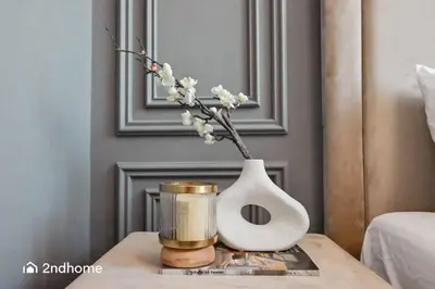 a table with a vase with a candle and a vase with flowers at Luxurious 1 Bed with Direct Access to Dubai Mall in Dubai