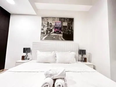 a bedroom with a white bed with a double decker bus at Lovely Newly Furnished Ocean View Studio in Royal Oceanic Tower in Dubai