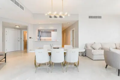 a dining room and living room with a table and chairs at Newly Designed 3 beds w marina eye view in Dubai