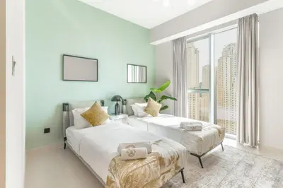 two white beds in a room with a window at Newly Designed 3 beds w marina eye view in Dubai