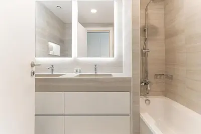 a bathroom with a sink and a tub and a mirror at Newly Designed 3 beds w marina eye view in Dubai