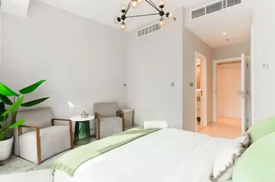 a white bedroom with a large bed and two chairs at Newly Designed 3 beds w marina eye view in Dubai