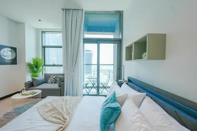 a bedroom with a bed and a living room at Urban Skyline City Comfort Studio in Dubai