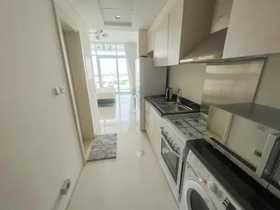 a kitchen with a sink and a stove top oven at Modern Condo With Wide City Views From Balcony in Dubai