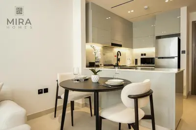 a kitchen with a table and chairs in a room at Mira Holiday Homes - Serviced 1 bedroom with canal view in Dubai