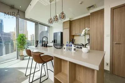 a kitchen with a counter and a large window at Mira Holiday Homes - Stylish 1 bedroom in Dubai Marina in Dubai