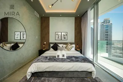 a bedroom with a large bed and a large mirror at Mira Holiday Homes - Stylish 1 bedroom in Dubai Marina in Dubai
