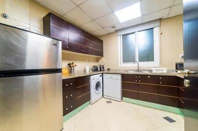 a kitchen with a refrigerator and a washer and dryer at 1BR Spacious Apartment in Marina Sail By PK Holidays in Dubai