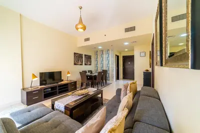 a living room with a couch and a tv at 1BR Spacious Apartment in Marina Sail By PK Holidays in Dubai