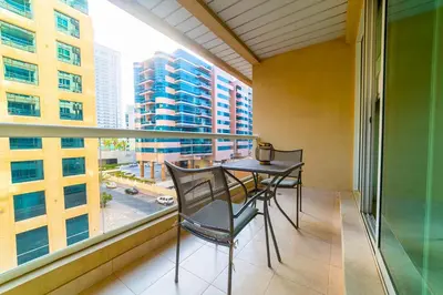 a balcony with a table and chairs and a large window at 1BR Spacious Apartment in Marina Sail By PK Holidays in Dubai