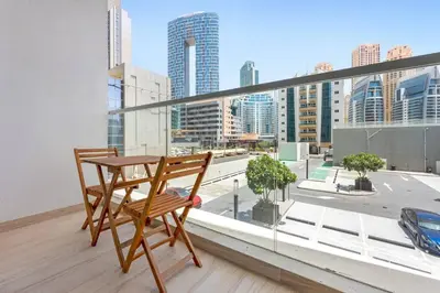 a table and chair on a balcony with a view of a city at StoneTree - Studio One Tower Studio - Amazing View and Facilities in Dubai